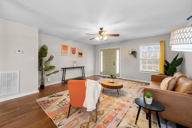 a living room with furniture a rug and a window