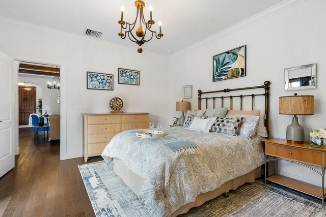 a bedroom with a large bed and a chandelier