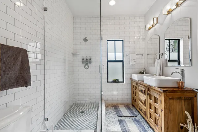 a bathroom with a double vanity sink a mirror and a shower