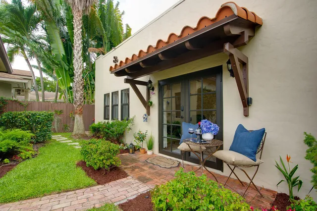 a view of a chair and table in backyard of the house