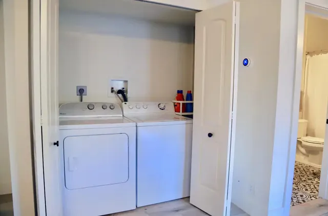 a utility room with dryer washer and a view of living area
