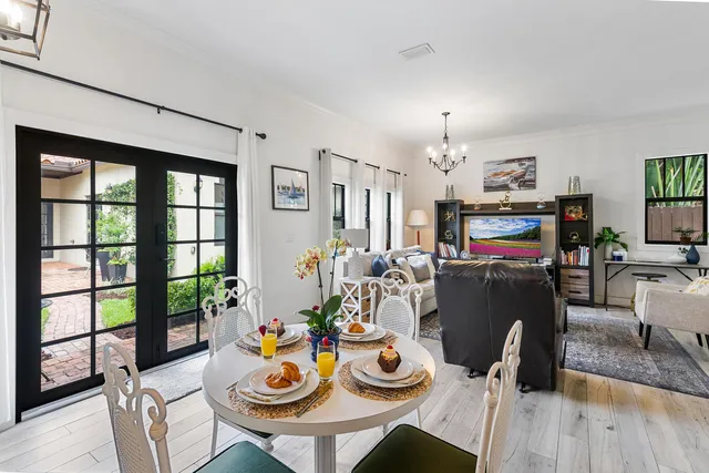 a view of a dining room with furniture a chandelier and wooden floor