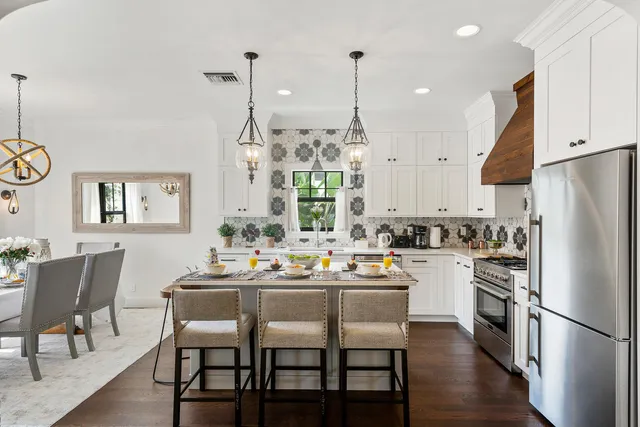 a kitchen with a dining table chairs refrigerator and cabinets