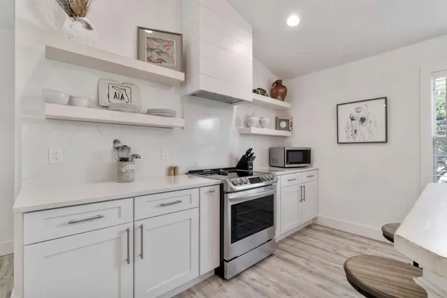 a kitchen with cabinets a stove and wooden floor