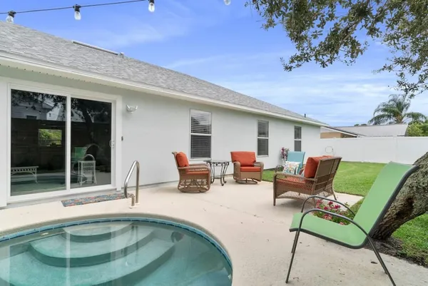 a view of pool with lawn chairs and couches with wooden floor