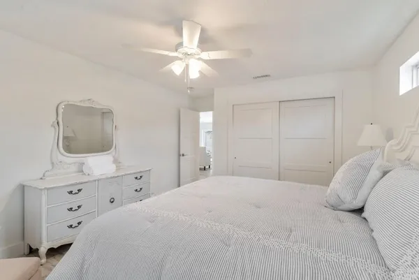 a bedroom with a bed a chandelier and mirror