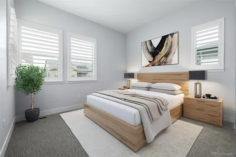 a bedroom with a bed and a computer on a table