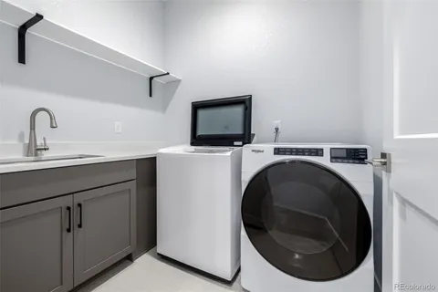 a living room with stainless steel appliances furniture and a flat screen tv