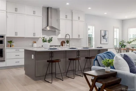 a kitchen with stainless steel appliances kitchen island granite countertop a sink a stove a dining table and chairs