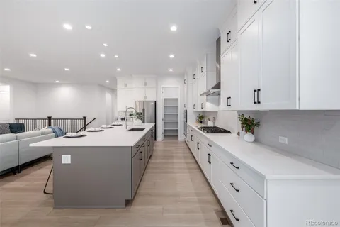 a large kitchen with stainless steel appliances lots of white cabinets