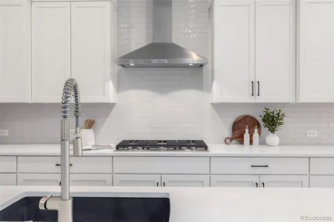 a kitchen with white cabinets and appliances