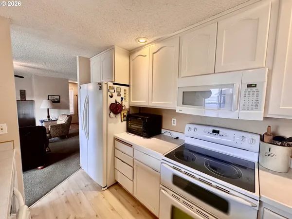 a kitchen with a refrigerator stove and white cabinets