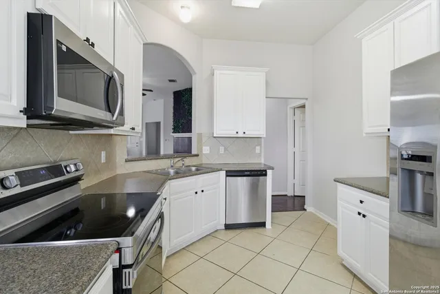 a kitchen with stainless steel appliances granite countertop a sink stove and microwave