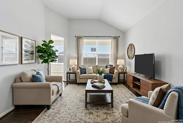 a living room with furniture flat screen tv and a large window