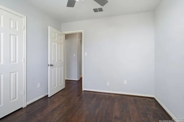 a view of an empty room with wooden floor