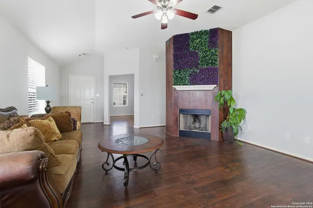 a living room with furniture a fireplace and a chandelier