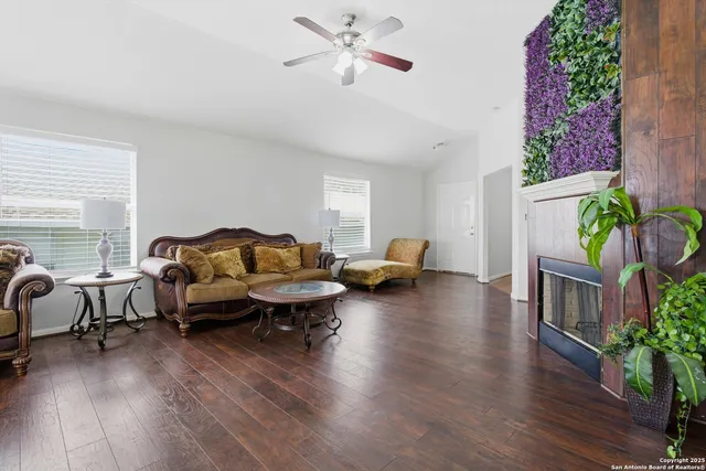 a living room with furniture floor to ceiling window and wooden floor