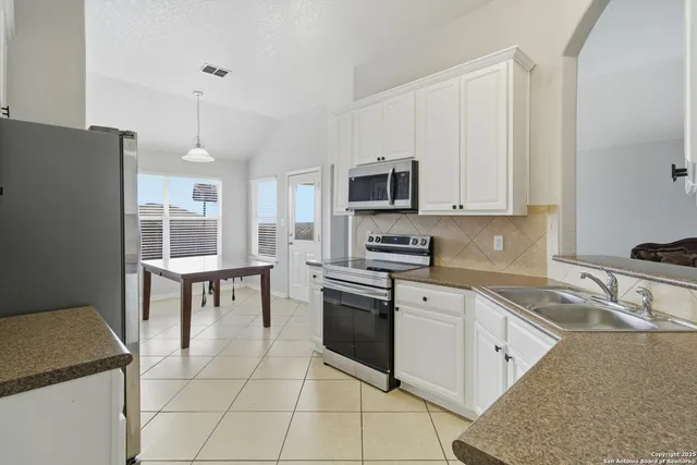 a kitchen with a stove a sink and a microwave