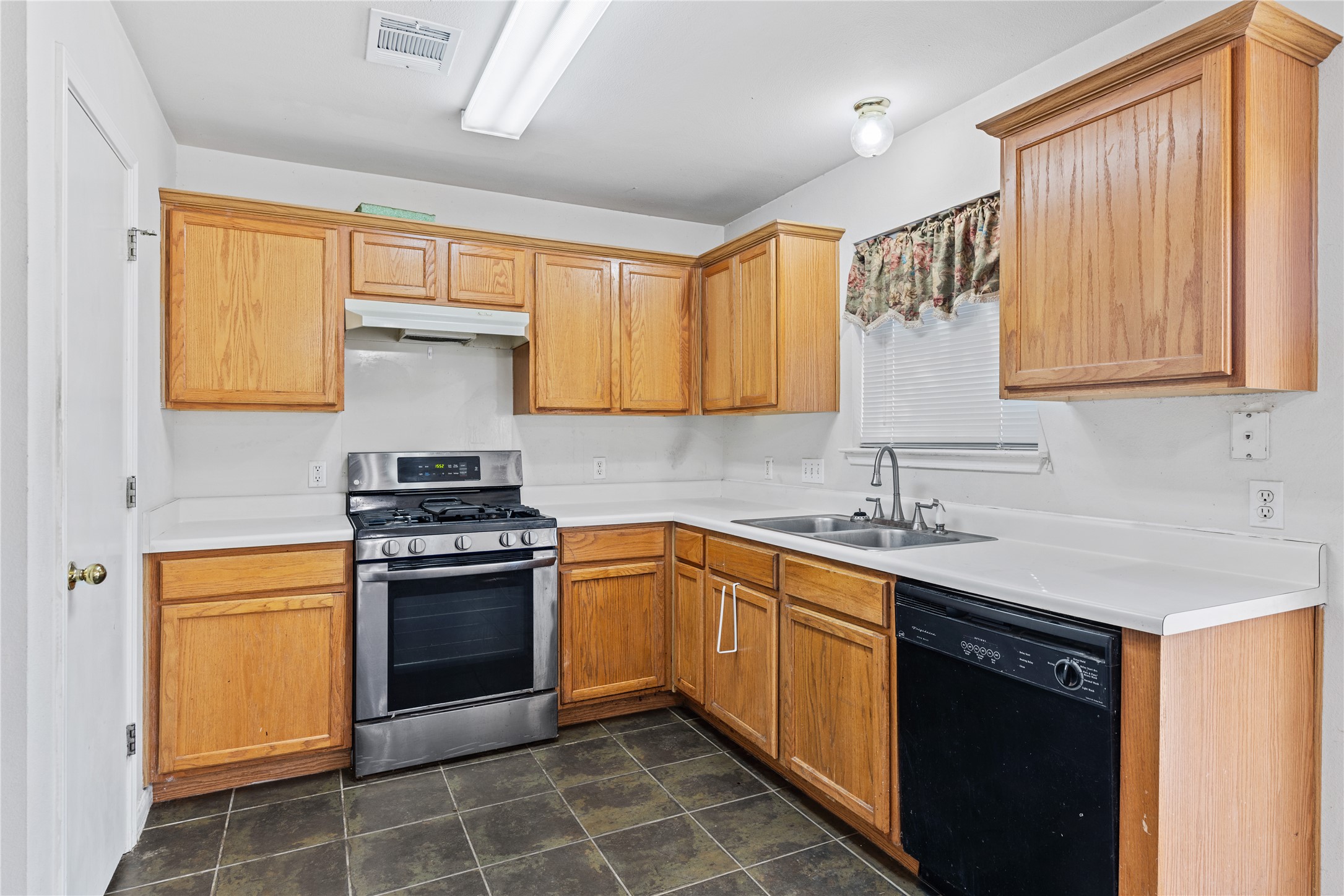 600 Tobin Drive Buda, TX 78610 - Photo 7 of 21 Kitchen featuring stainless steel gas range, dishwasher, and light countertops