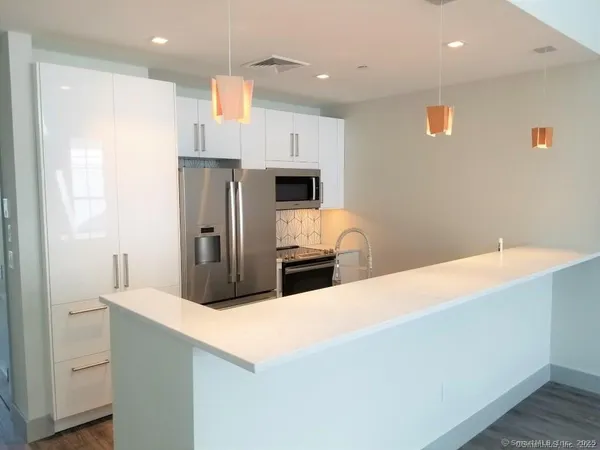 a kitchen with stainless steel appliances a refrigerator and a microwave