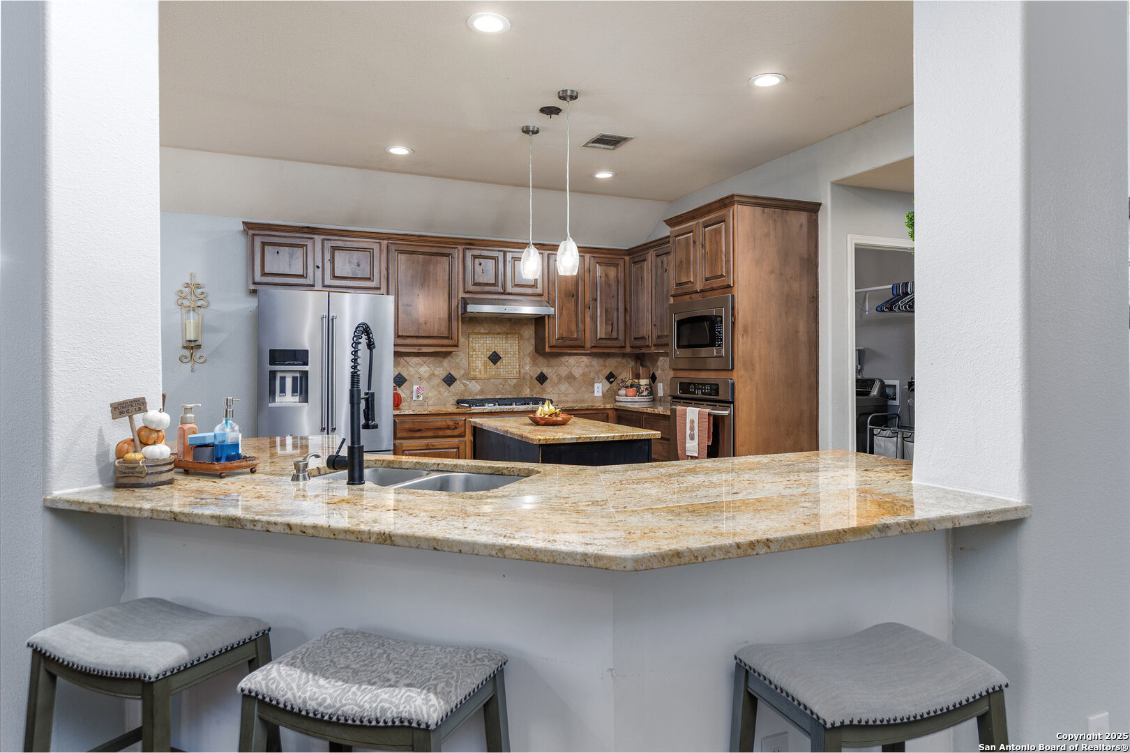 9026 Colfax Helotes, TX 78023 - Photo 24 of 40 a kitchen with refrigerator a sink and chairs
