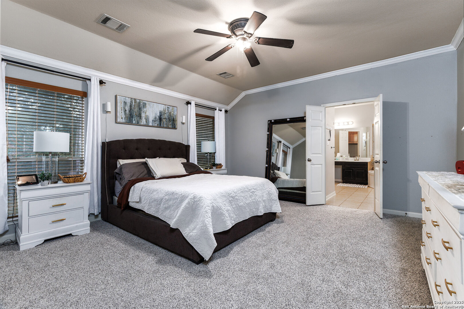 9026 Colfax Helotes, TX 78023 - Photo 26 of 40 a spacious bedroom with a large bed and a chandelier