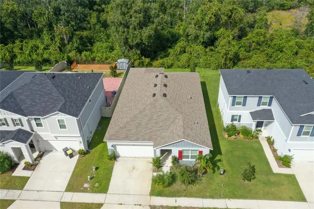 an aerial view of a house with a garden and trees