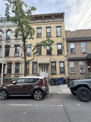 a car parked in front of a big house
