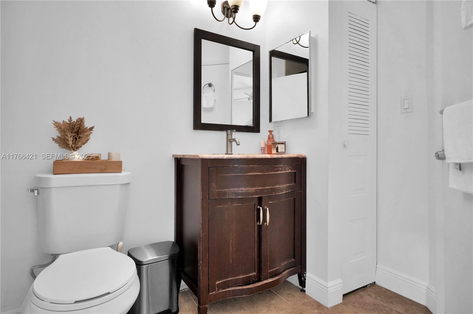 9503 Southwest 140th Court, Unit 9503 Miami, FL 33186 - Photo 18 of 32 a bathroom with a toilet sink and mirror