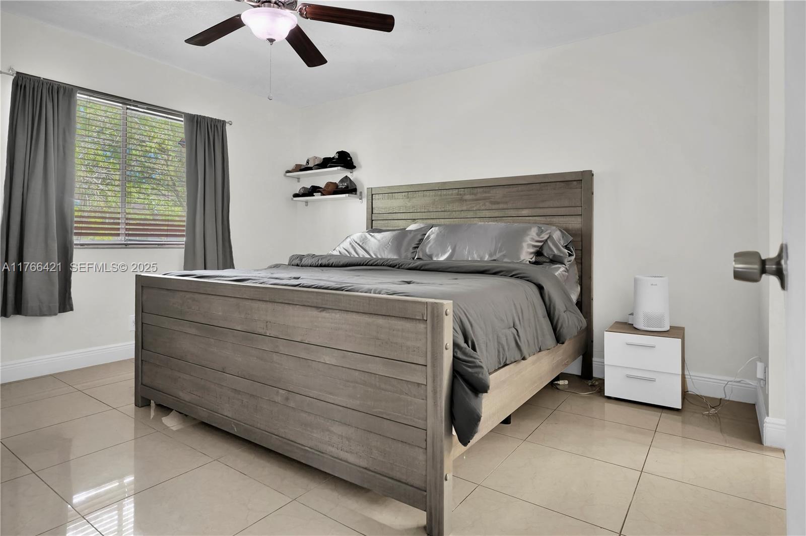 9503 Southwest 140th Court, Unit 9503 Miami, FL 33186 - Photo 21 of 32 a bedroom with a bed and a chandelier