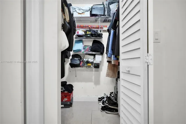 walk in closet with clothes and shoes