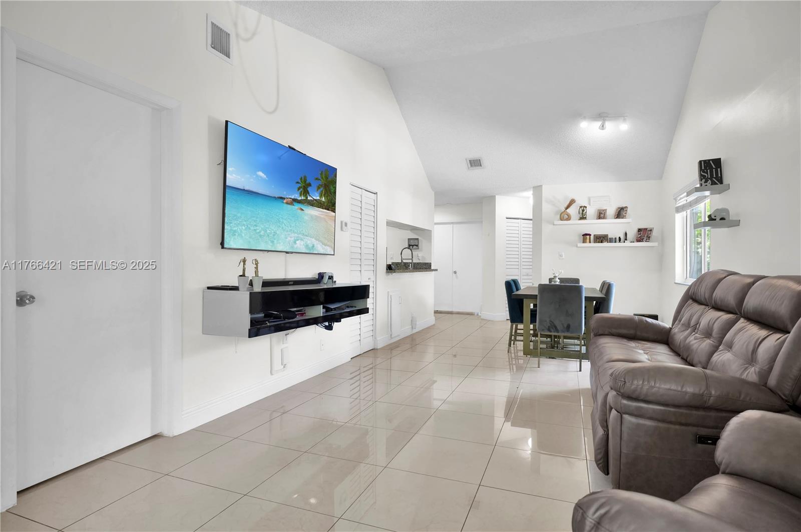 9503 Southwest 140th Court, Unit 9503 Miami, FL 33186 - Photo 9 of 32 a living room with furniture and kitchen view