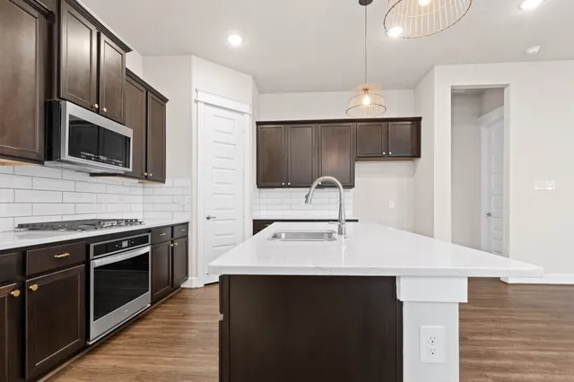 a kitchen with stainless steel appliances a sink stove and microwave