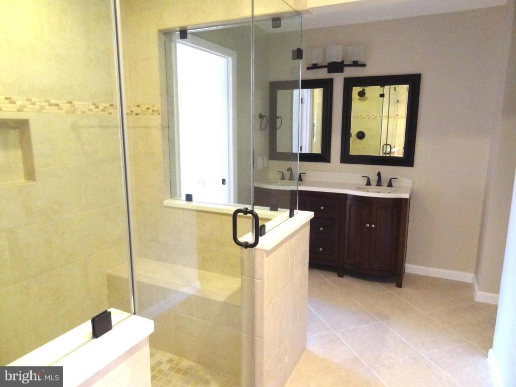 1808 Pepperidge Lane Reston, VA 20191 - Photo 22 of 24 a bathroom with a double vanity sink a mirror and a bathtub