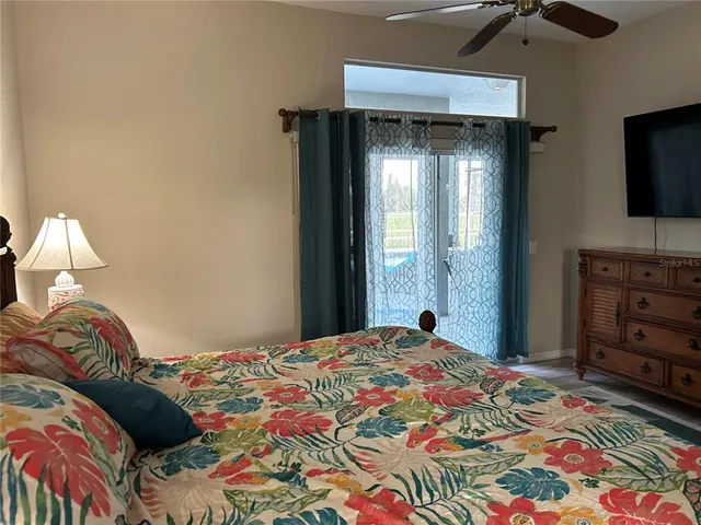 a bedroom with a bed and a flat tv screen on dresser