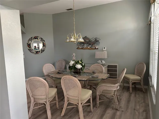 a dining room with furniture a chandelier and wooden floor