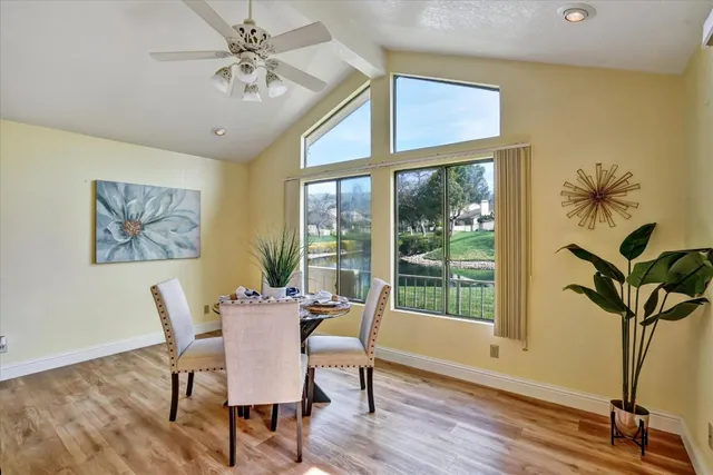 a dining room with furniture potted plants and wooden floor