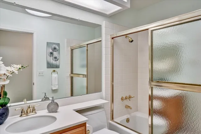 a bathroom with a shower sink and mirror