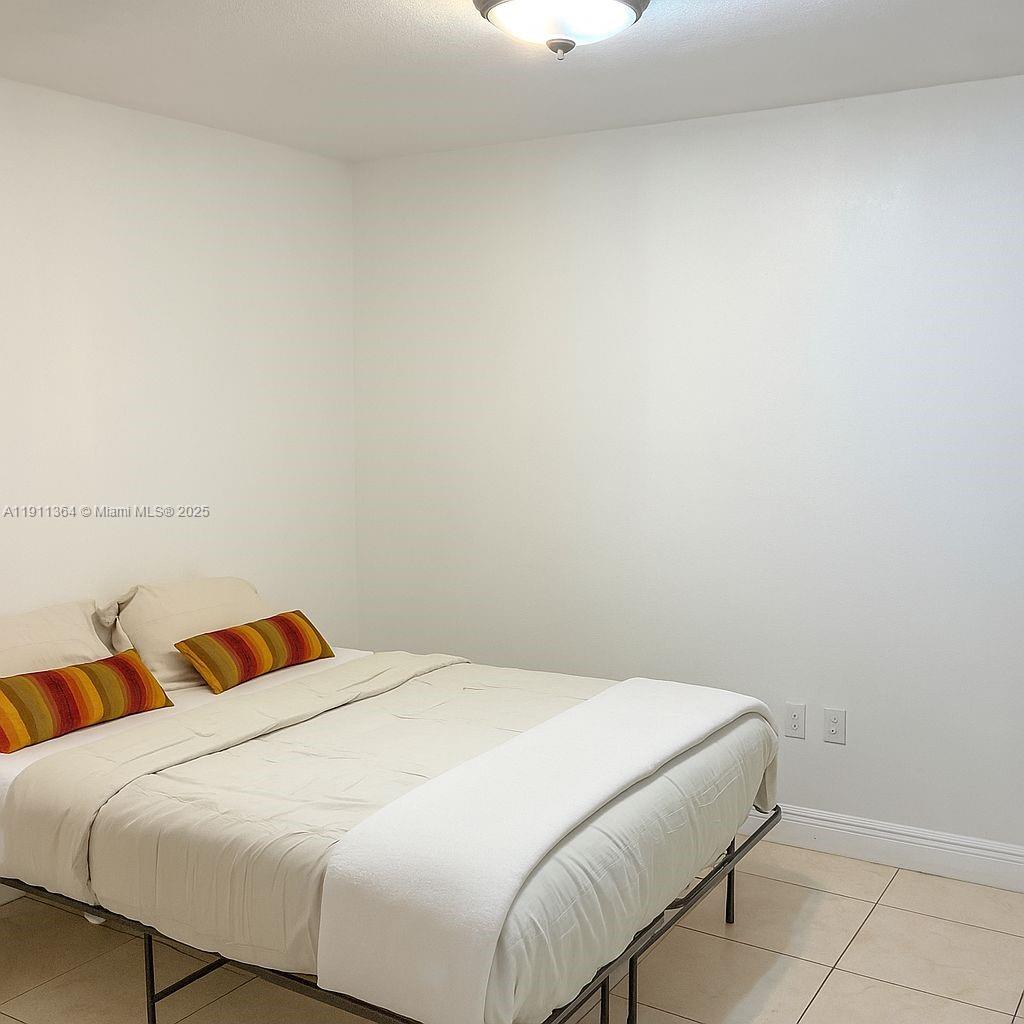 6345 Collins Avenue, Unit TH2 Miami Beach, FL 33141 - Photo 4 of 8 a bedroom with a bed and a lamp
