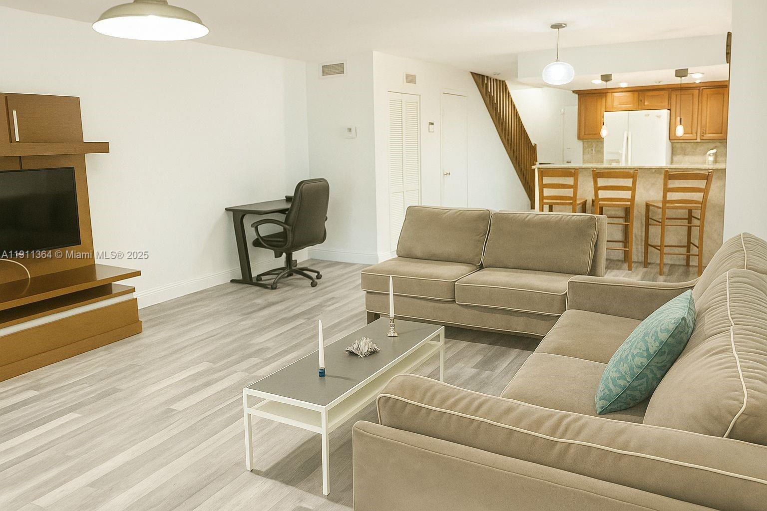 6345 Collins Avenue, Unit TH2 Miami Beach, FL 33141 - Photo 6 of 8 a living room with furniture and a flat screen tv