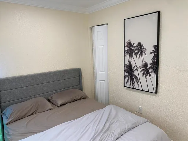 a bedroom with a bed and a painting on the wall