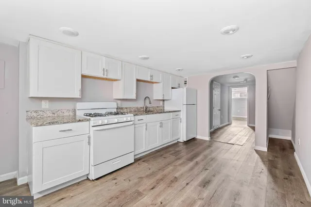 a view of a room that has wooden floor and bench in it