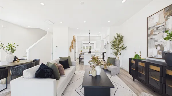 a large white kitchen with a stove a sink dishwasher and a fireplace with wooden floor