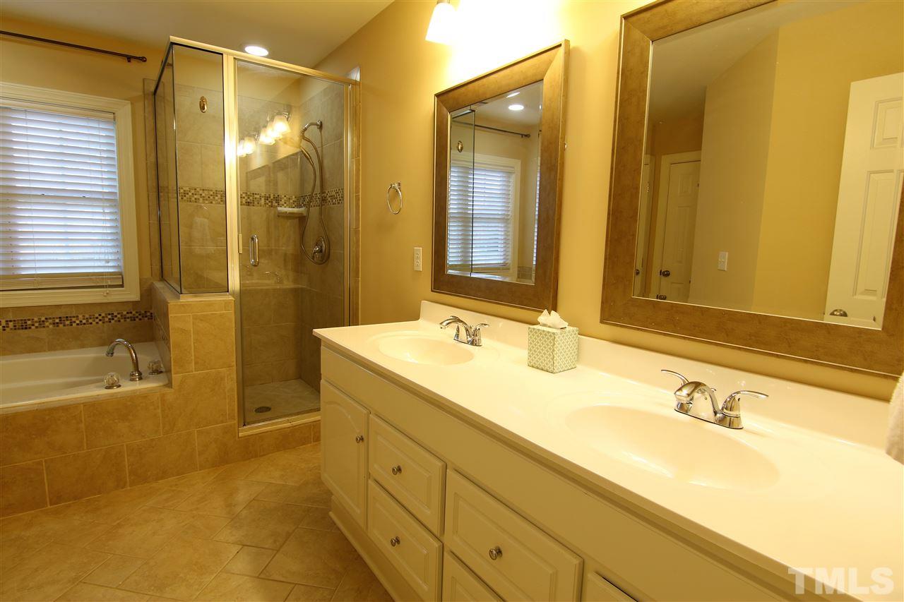 1005 Nortonbridge Road Raleigh, NC 27603 - Photo 14 of 25 a bathroom with a granite countertop sink mirror and a bath tub