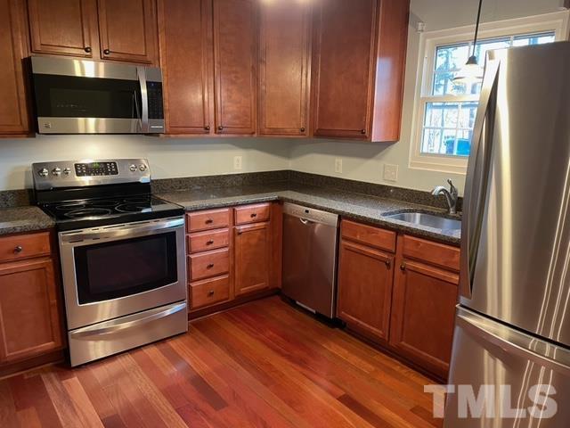 6325 New Market Way, Unit 6325 Raleigh, NC 27615 - Photo 1 of 13 a kitchen with stainless steel appliances granite countertop a stove a refrigerator and a microwave