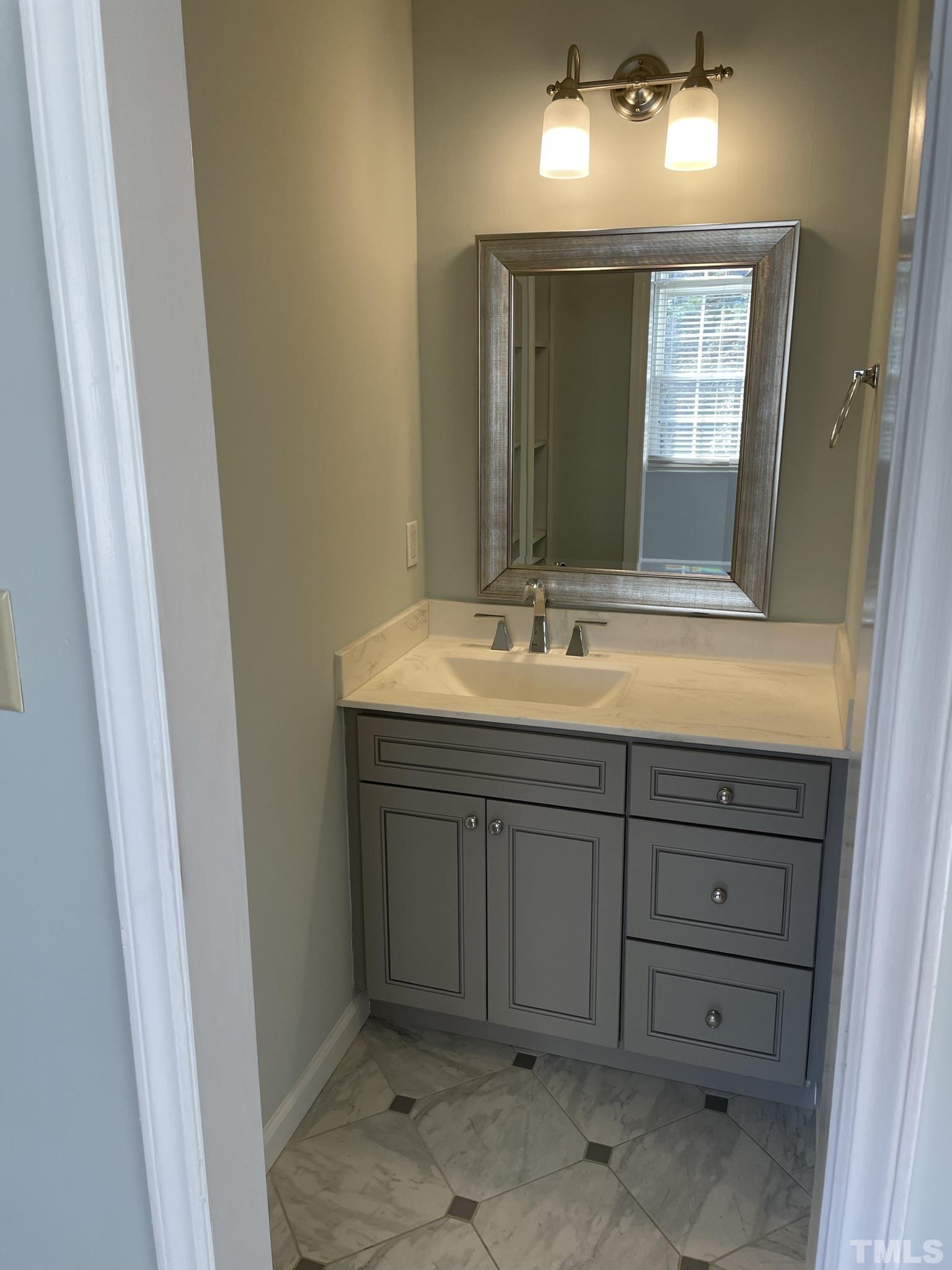6325 New Market Way, Unit 6325 Raleigh, NC 27615 - Photo 11 of 13 a bathroom with a sink and a mirror