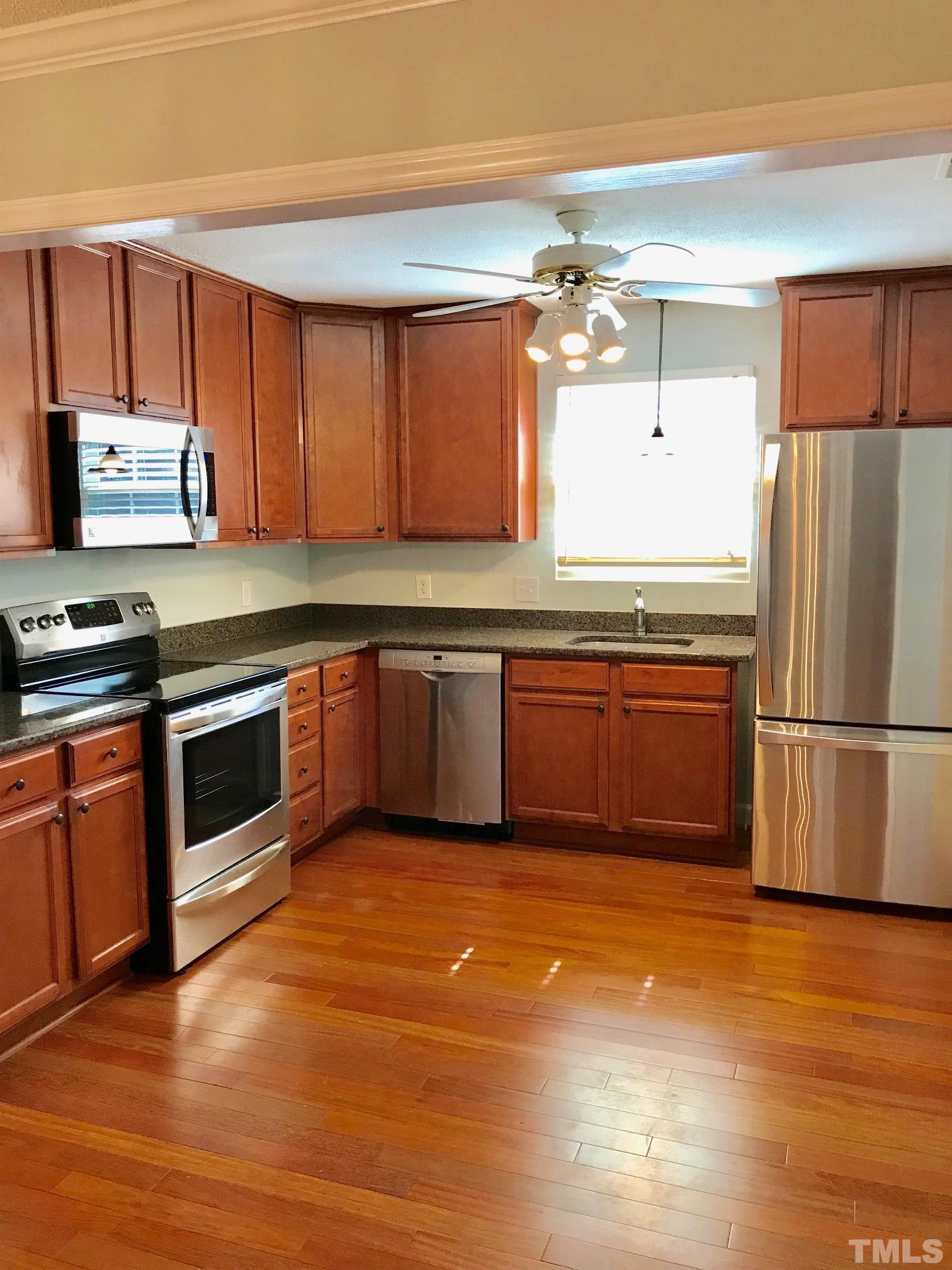 6325 New Market Way, Unit 6325 Raleigh, NC 27615 - Photo 4 of 13 a kitchen with stainless steel appliances granite countertop a stove a sink and a refrigerator
