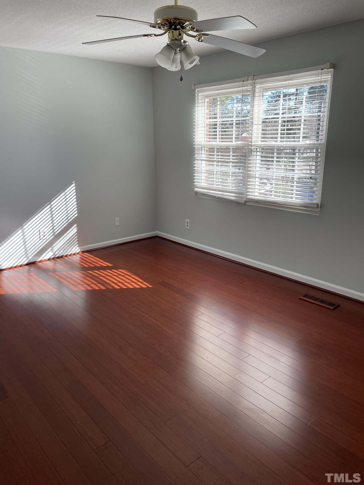 6325 New Market Way, Unit 6325 Raleigh, NC 27615 - Photo 9 of 13 an empty room with wooden floor fan and windows