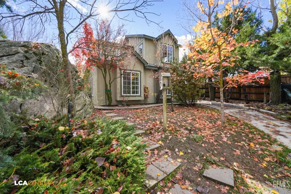 a view of a house with a yard and pathway