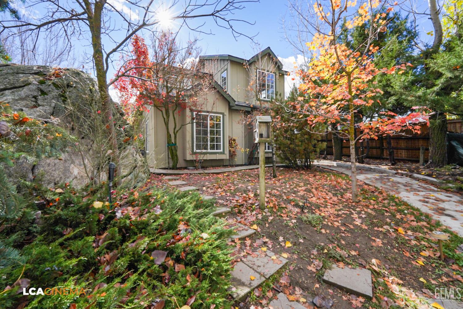 a view of a house with a yard and pathway